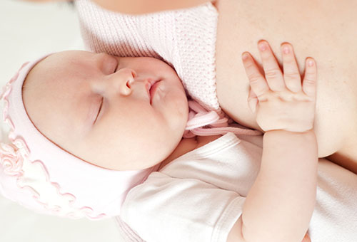 Новорожденный спит на руках у мамы