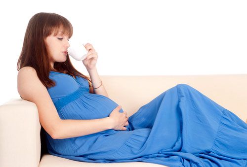 Беременная женщина пьет чай